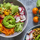 Vegan bowl with romanesco, avocado, carrots, tomatoes, and more